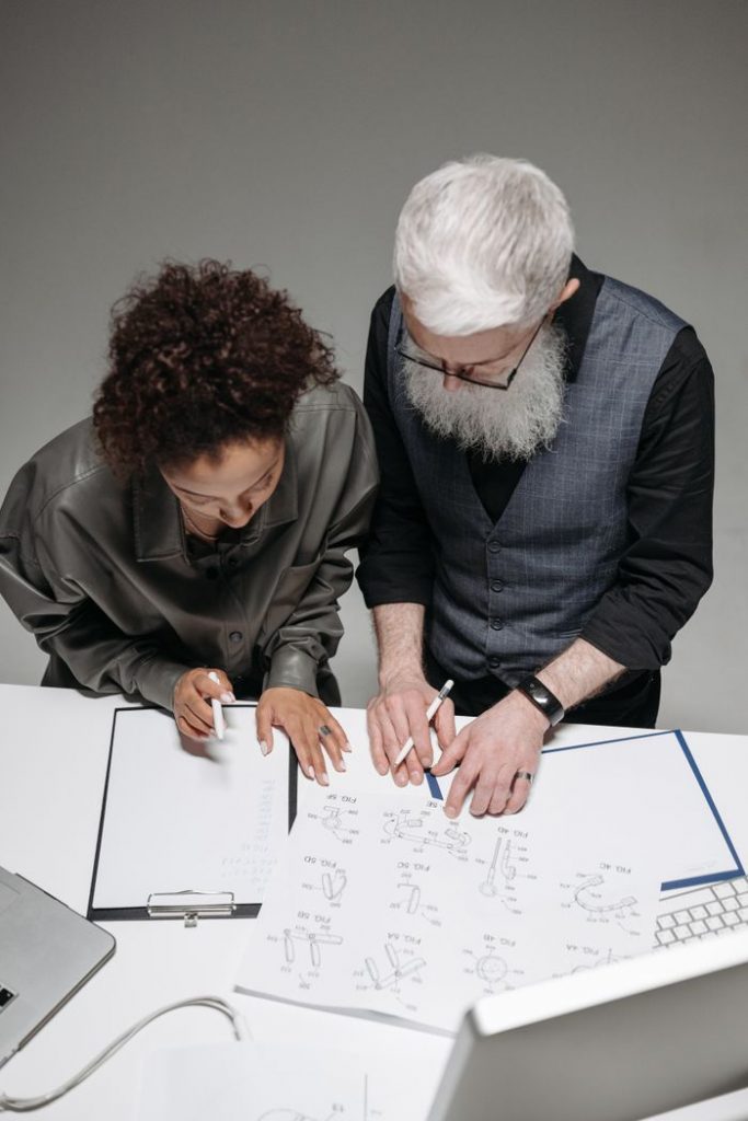 Top view of diverse colleagues collaborating over design drafts in a modern office.